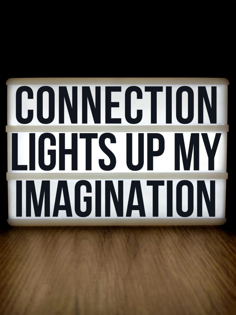 A motivational message displayed on a lightbox sign with a wooden background.