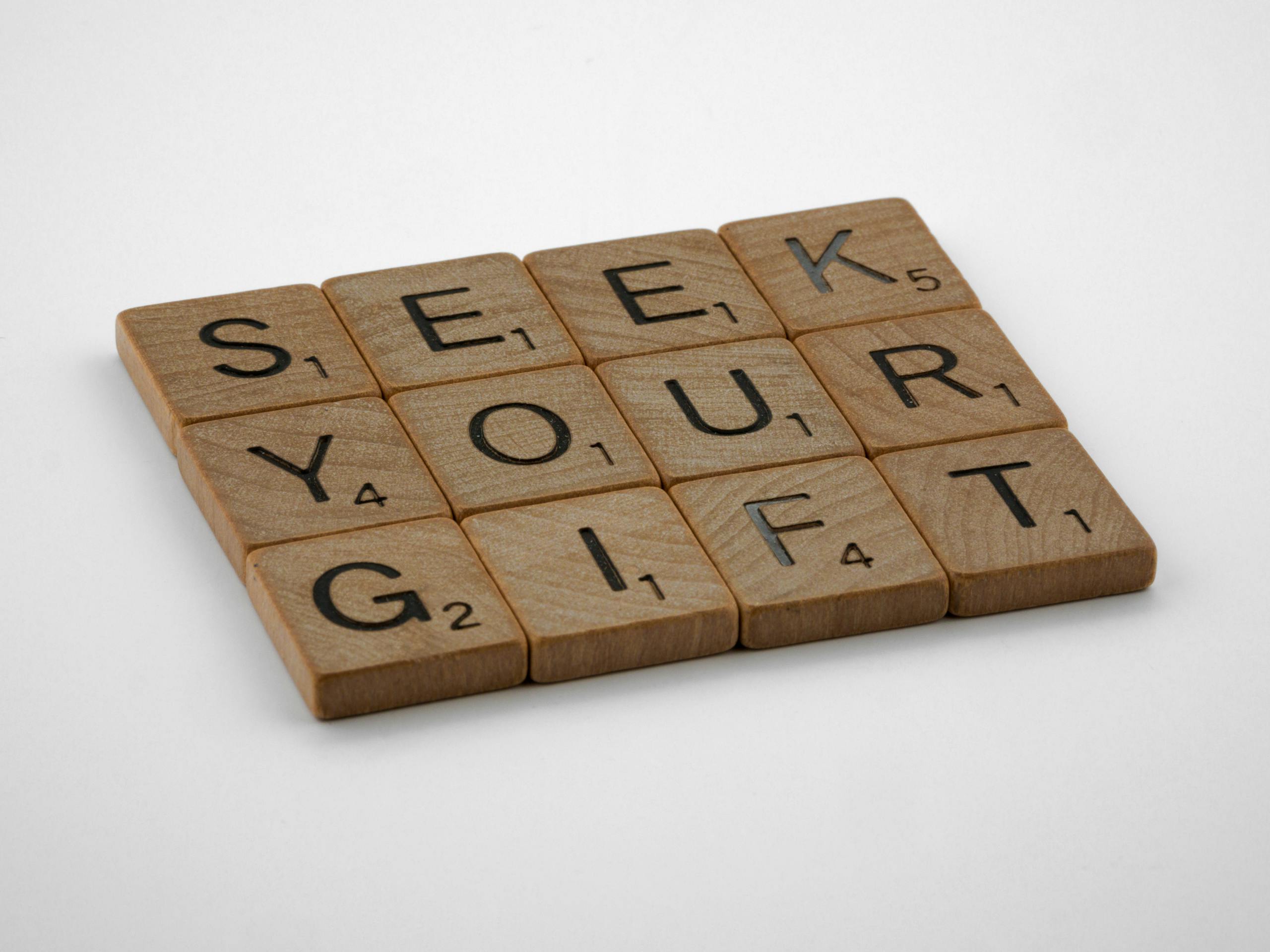 Scrabble tiles spelling out 'Seek Your Gift', highlighting creativity and inspiration.